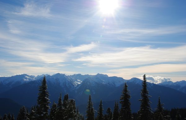 the sun shines brightly over a mountain range