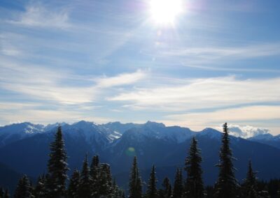 the sun shines brightly over a mountain range