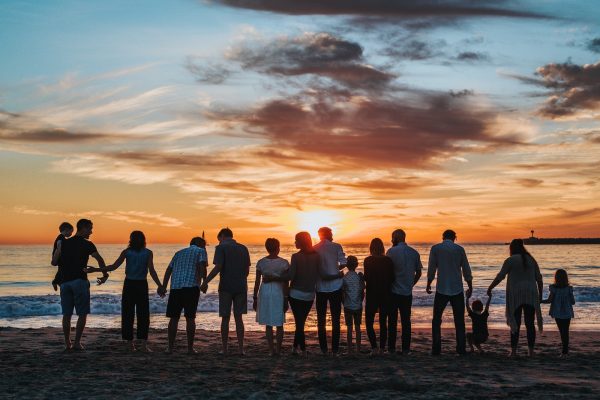 Photo by Tyler Nix people standing on shore during golden hour