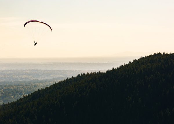Photo by Dave Hoefler person paragliding near mountain