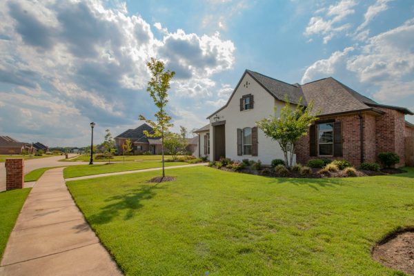 Photo by Ronnie George white and brown house near green grass field under white clouds and blue sky during daytime